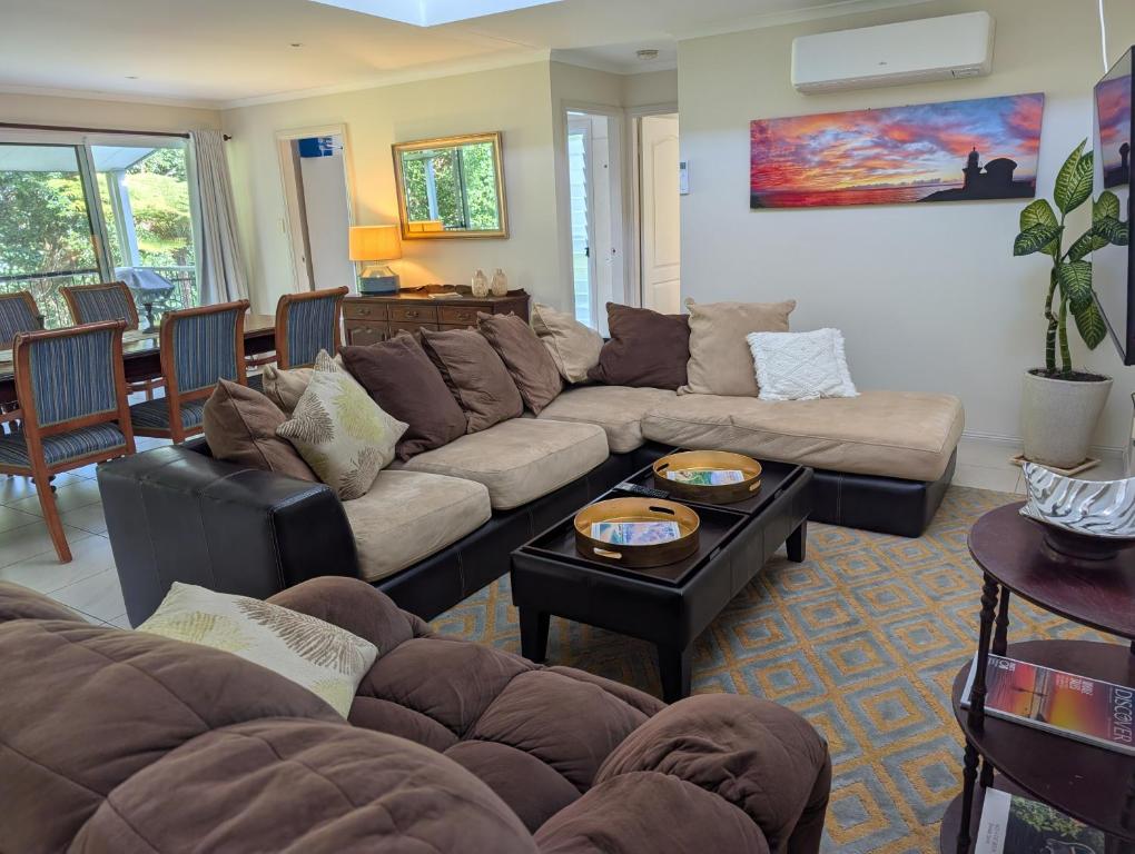 a living room with a couch and a table at Rainforest Cottage in Port Macquarie