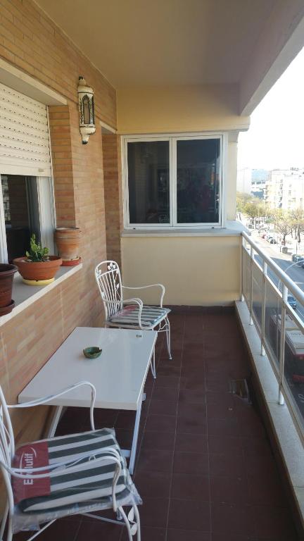 balkon z białym stołem i krzesłami w obiekcie Apartamento Eduardo Dato w Sewilli