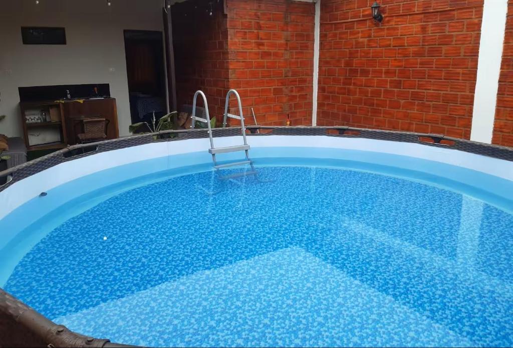 a large blue swimming pool with a chair in it at Mítica, Casa Hospedaje in Sauce