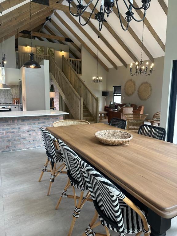 a dining room with a wooden table and chairs at Fallen Oak Villa 2 in George