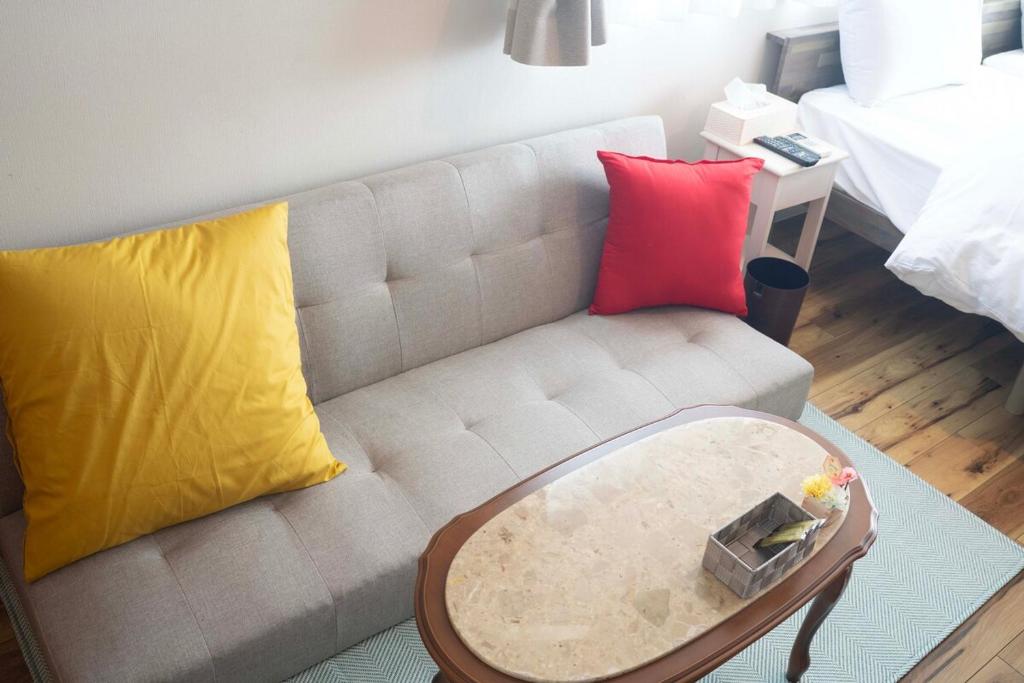 ein Wohnzimmer mit Sofa und Tisch in der Unterkunft 宿Luce in Okayama