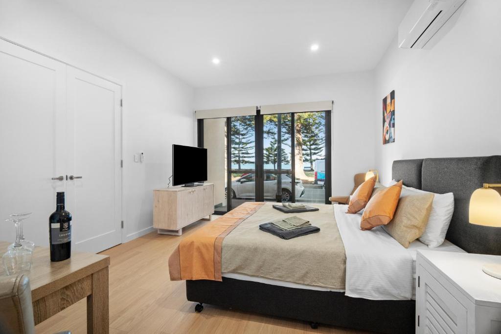 a bedroom with a bed and a table and a tv at Harborview Modern Studio 11F in Victor Harbor