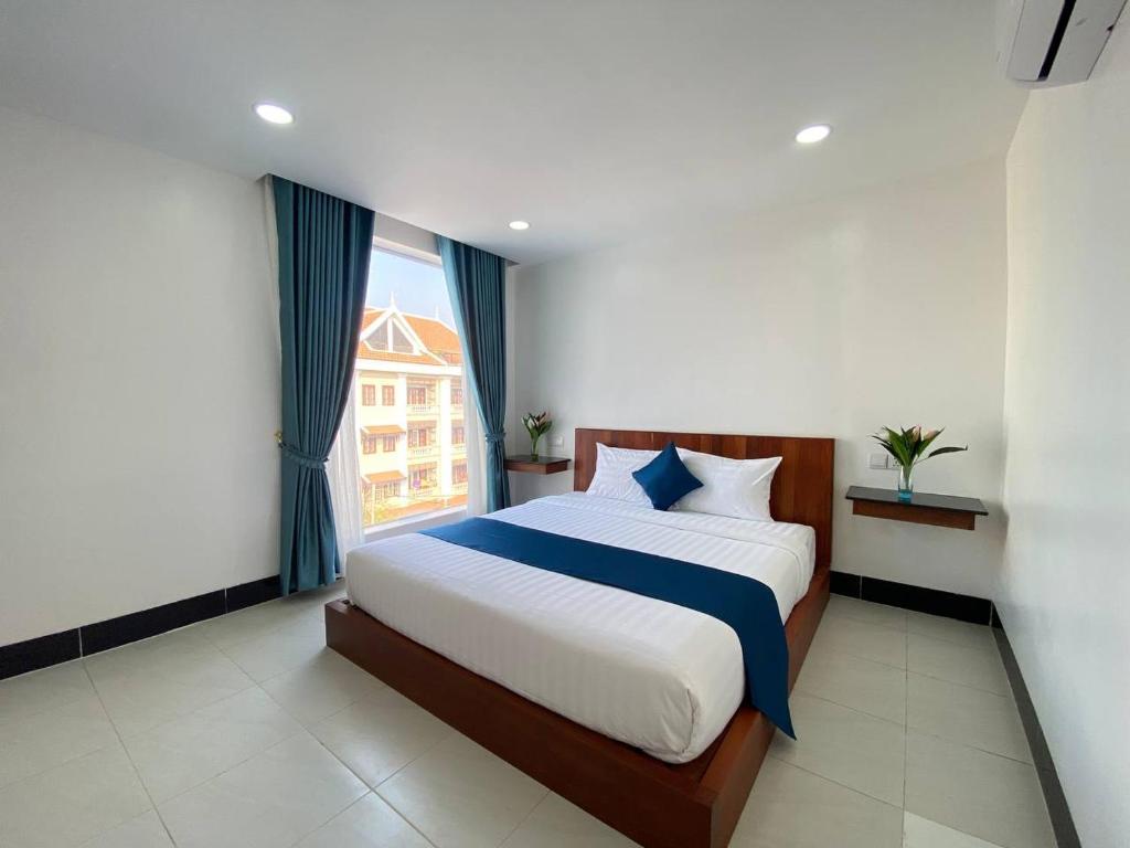 a bedroom with a large bed and a window at HomeStore Apartment in Siem Reap