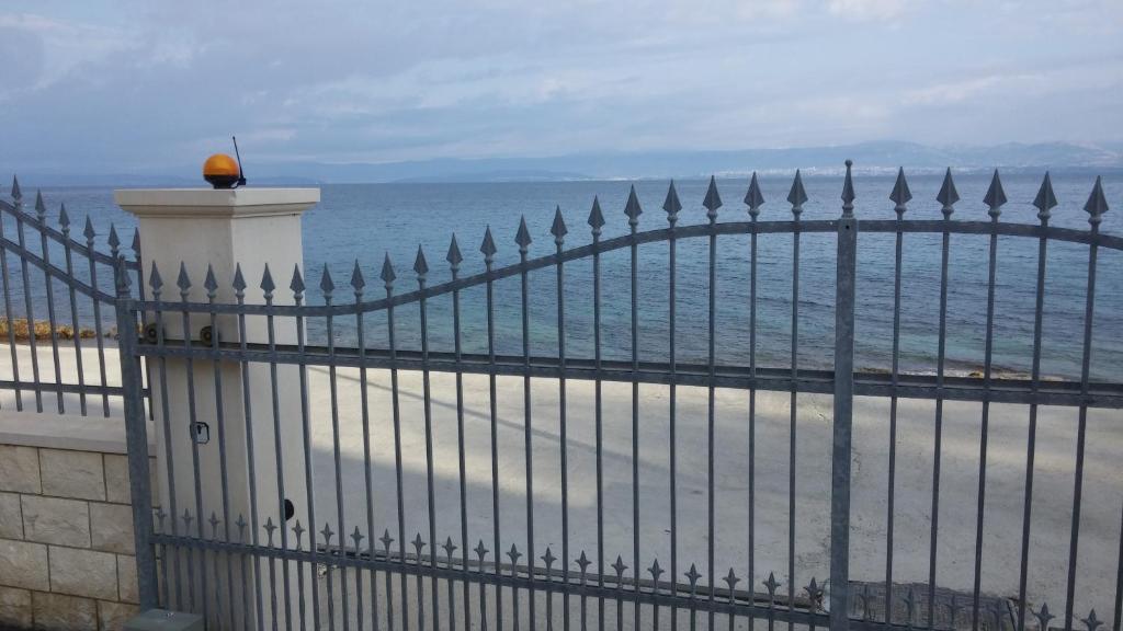a fence on the beach with the ocean behind it at Apartments on Gorana Pavlova 24 in Sutivan