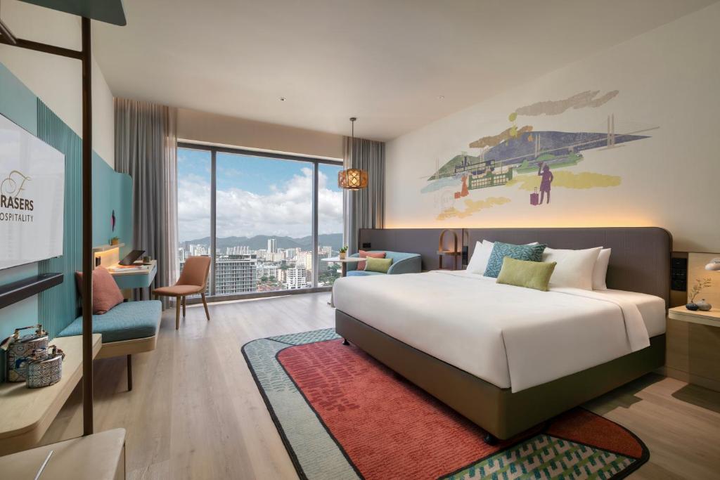a hotel room with a large bed and a desk at Capri by Fraser, Penang in George Town