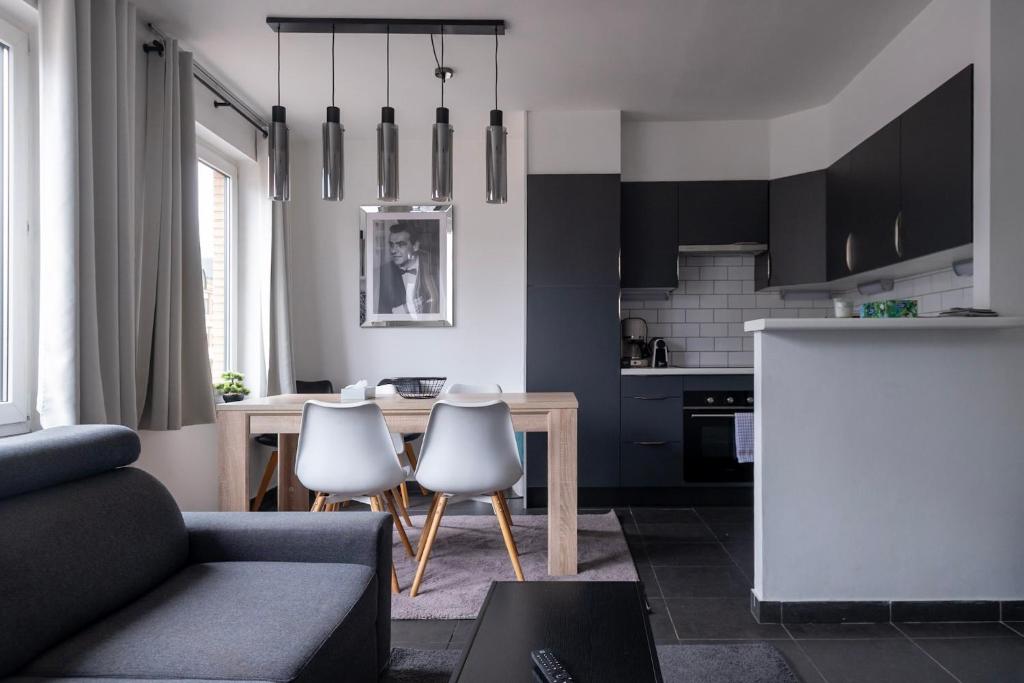 a living room with a couch and a table and chairs at Appartement Ann in Blankenberge