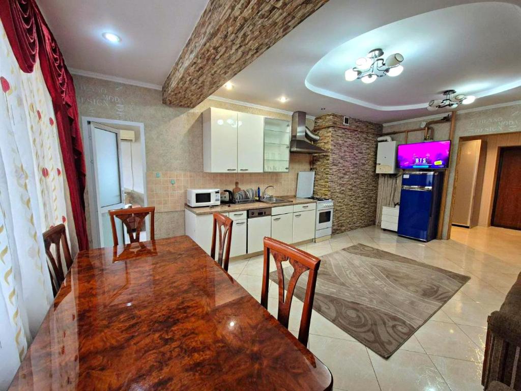 a kitchen with a wooden table and chairs in it at Apartments Chisinau in Chişinău