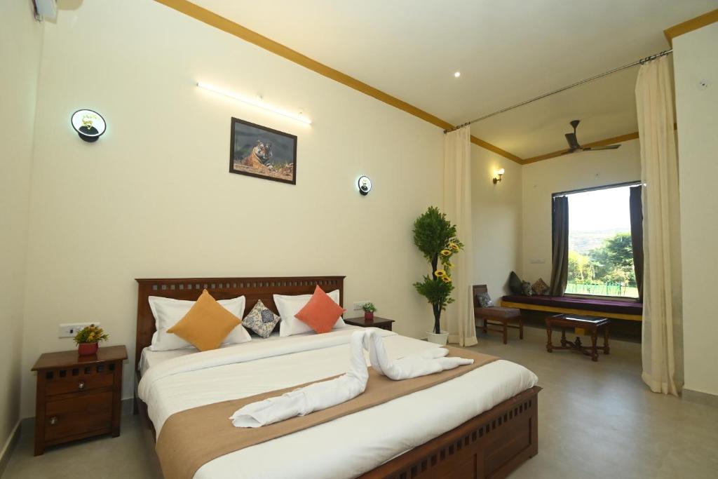 a bedroom with a large bed and a window at Baghin Resort in Khilchipur