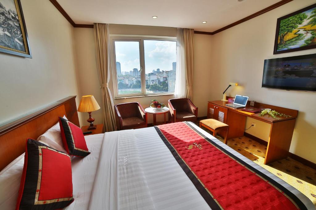 河內的住宿－陽光1號酒店，配有一张床、一张书桌和一扇窗户的酒店客房