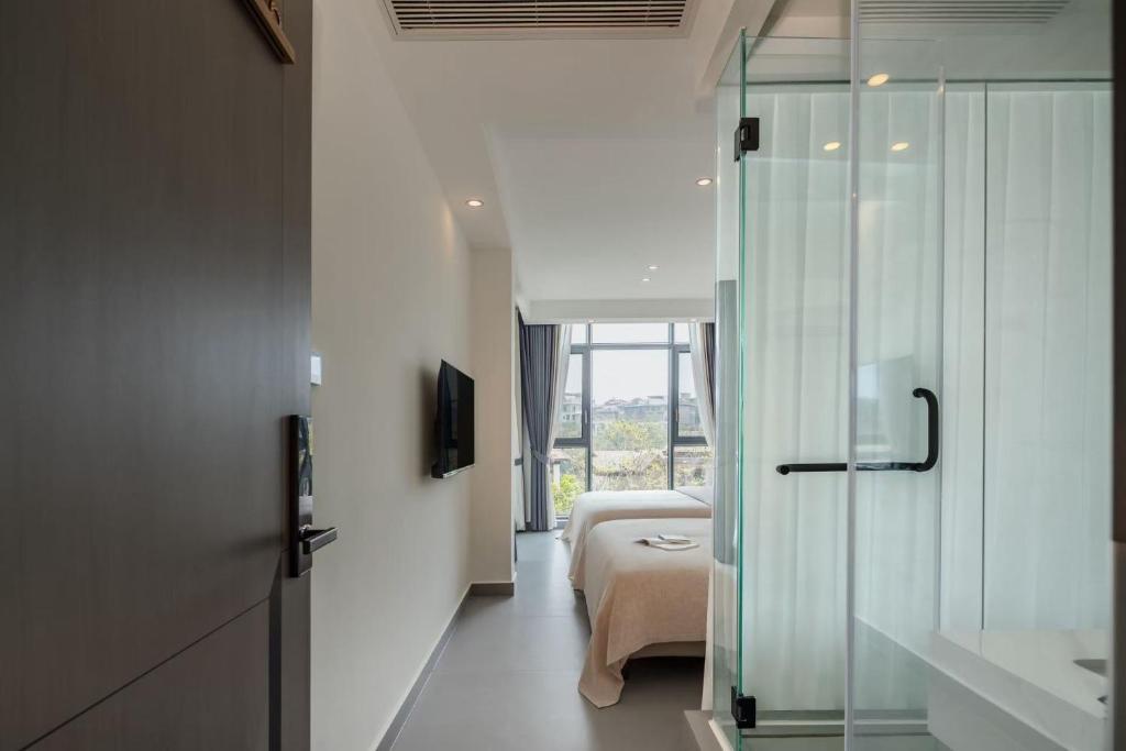 a bathroom with a bed and a glass shower at 样样好民宿 in Jinghong