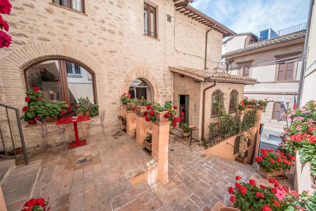 un patio de un edificio con macetas y flores en Hotel Sorella Luna en Assisi