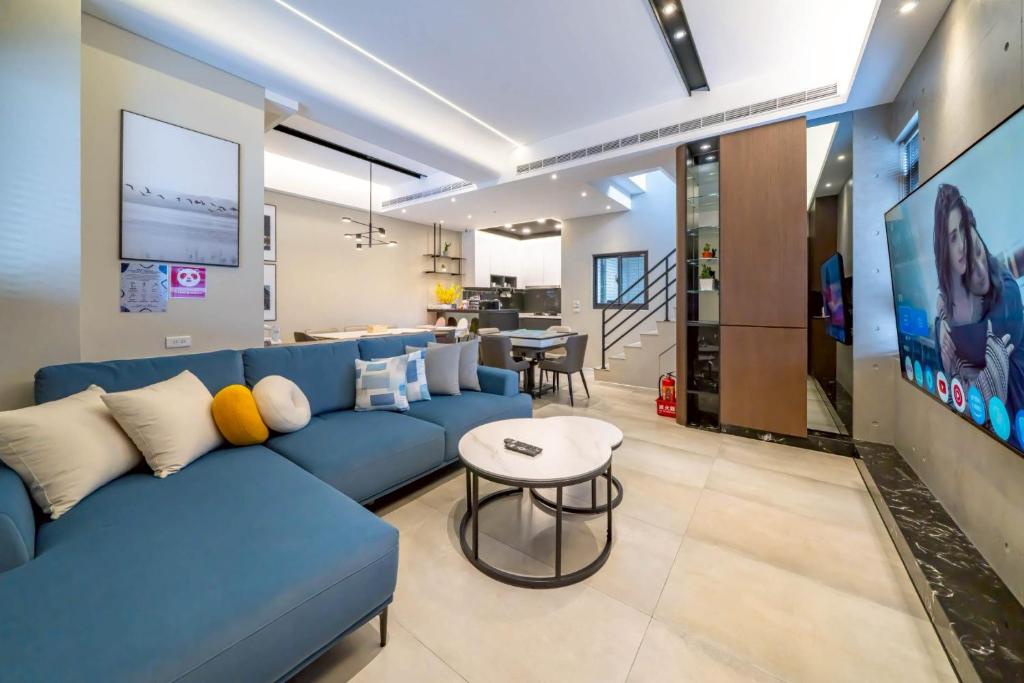 a living room with a blue couch and a table at Sunlight Heyun B&B in Yuanshan