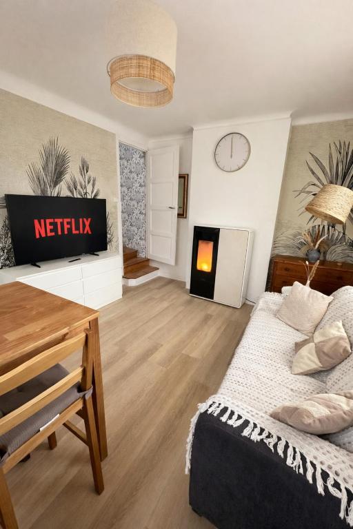 a living room with a bed and a tv at Charmante maison moderne et cosy in Aunay-sur-Odon