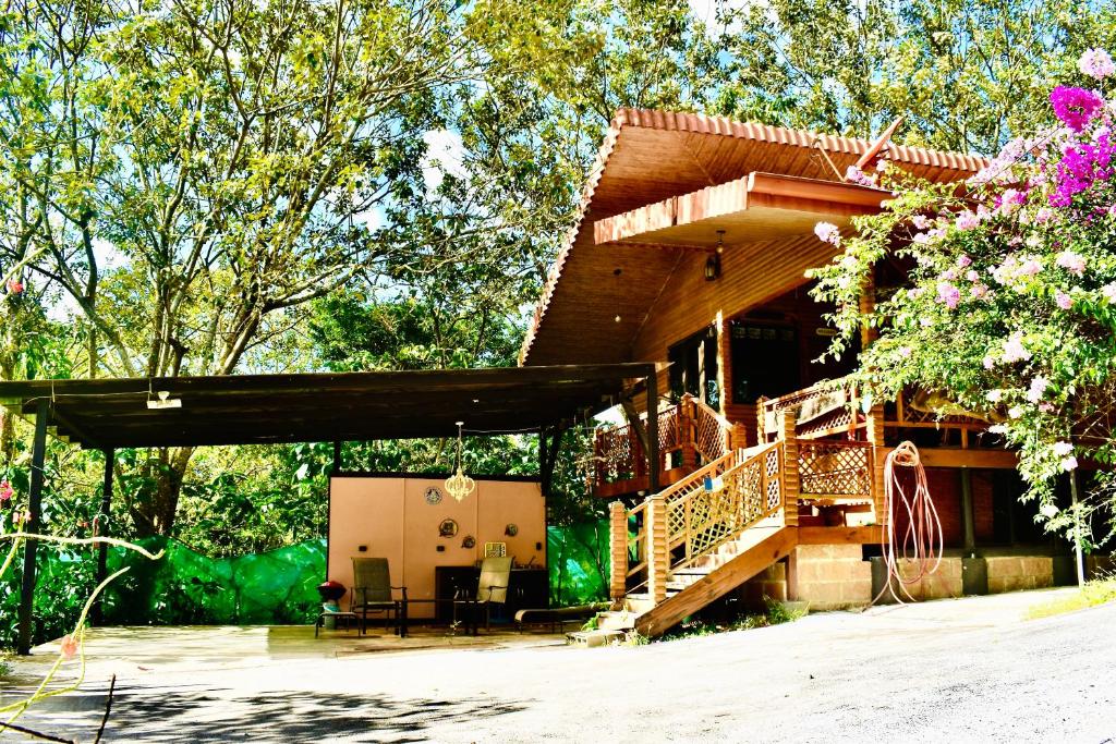 a house with a porch and a deck at Cabaña Colibrí - Parking in Sarchí