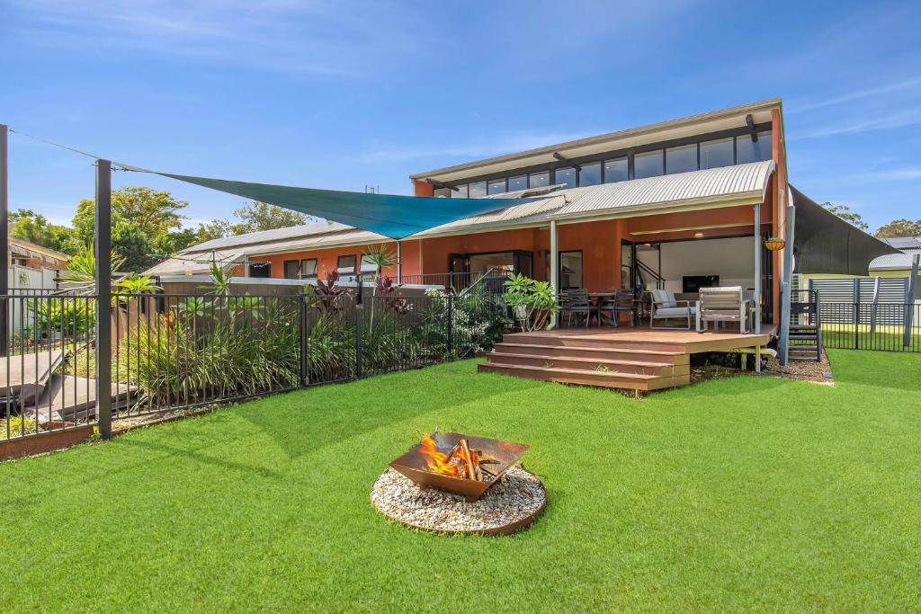 a backyard with a fire pit and a house at Sunsets on Kalang in Urunga