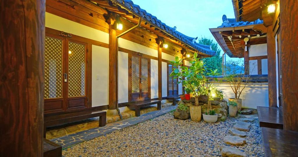 a courtyard of a house with some plants and lights at Jeonju Hanok Agbae in Jeonju