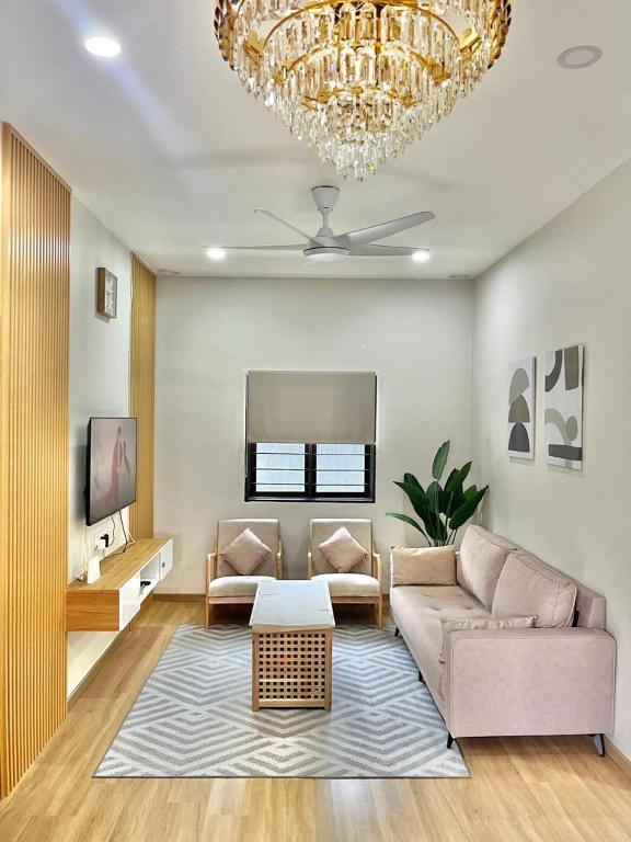 a living room with a couch and a chandelier at Desa Ibol Cottage and River - Max 10Pax in Kampong Sumpitan