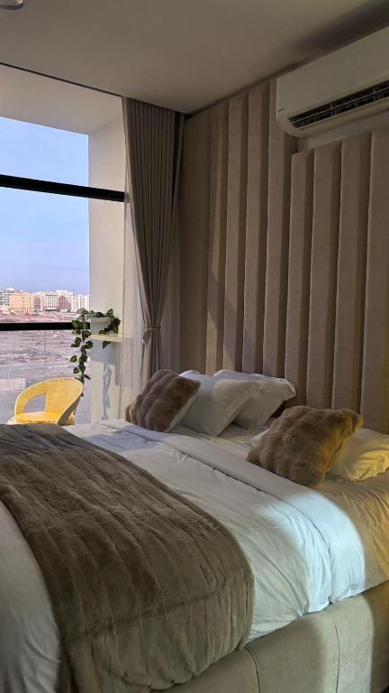 a bedroom with a large bed with a large window at Alaziba view in ‘Udhaybah