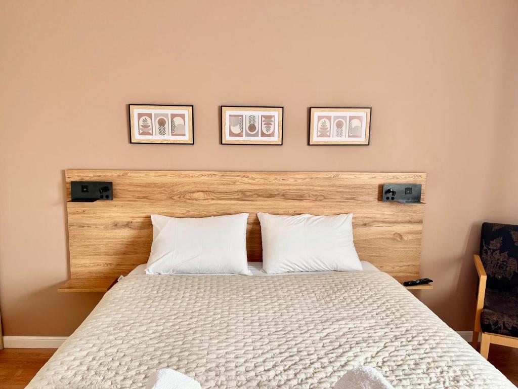 a bedroom with a bed with three pictures on the wall at SUNNY 3, Two-bedroom apartment with parking in Komotini