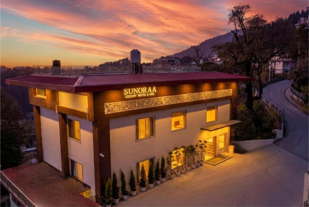 a building with a sign on the side of it at Sunoraa Luxury Hotel & Spa in Mussoorie