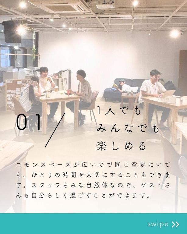 a group of people sitting at tables in a room at ゲストハウスONE Miyakojima 女性におすすめ 広い共有スペースあり 一人でのんびりも交流もできる宿 in Miyako-jima