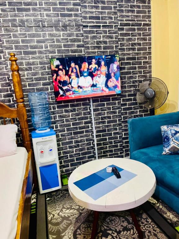 a living room with a couch a table and a picture at Serenity Suites Studio in Busia