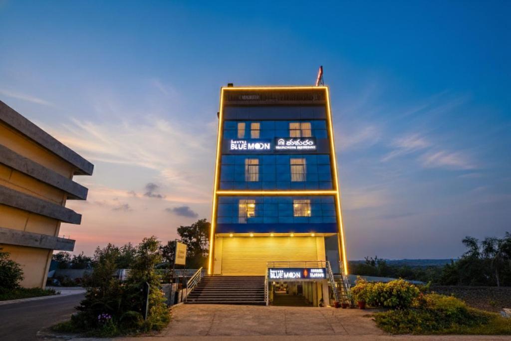 a building with a sign on the side of it at FabHotel Blue Moon in Hanamkonda