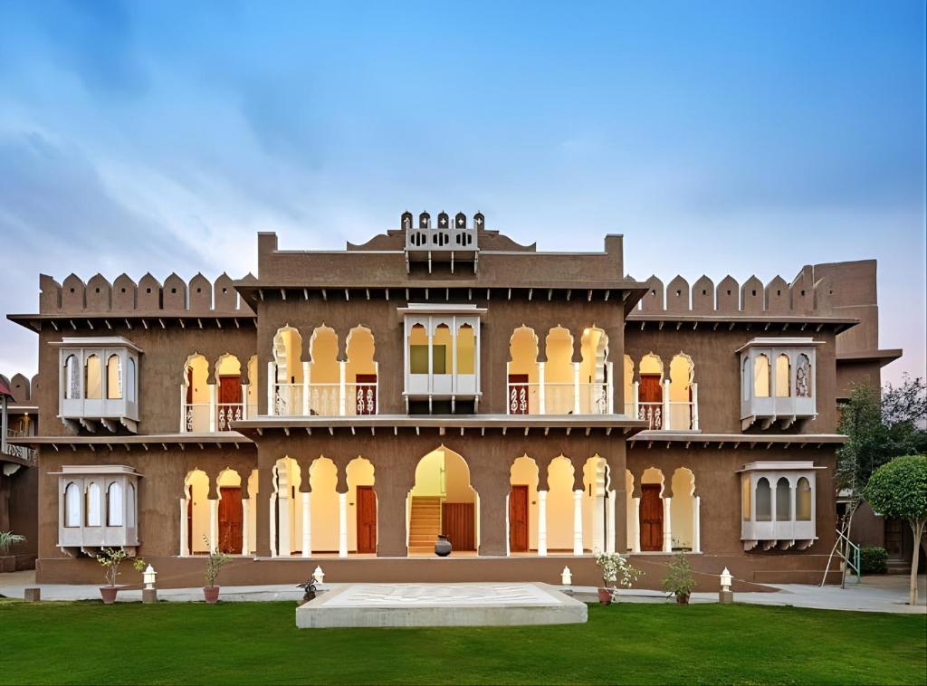 a large building with a lawn in front of it at Pushkar Fort - Luxury Heritage Resort in Pushkar