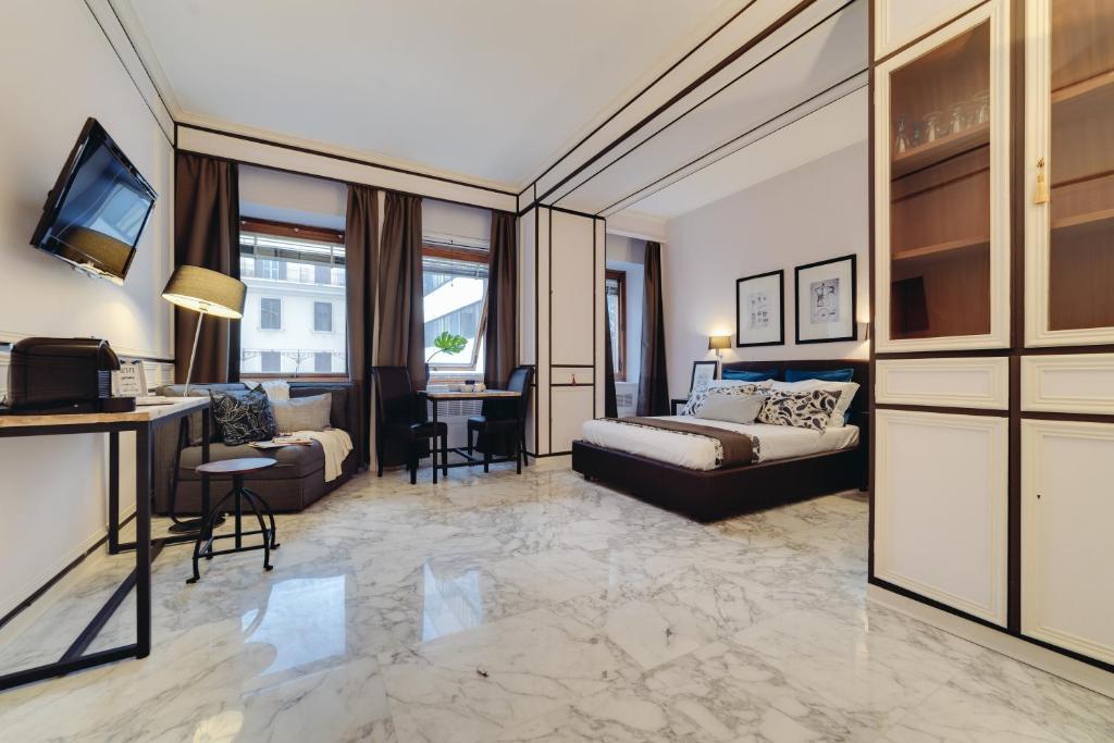 un ampio soggiorno con un letto e un divano di Repubblica Central Suite a Roma