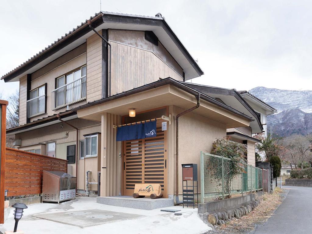 a house with a store front with a fence at わのおうち善 in Nitanzawa
