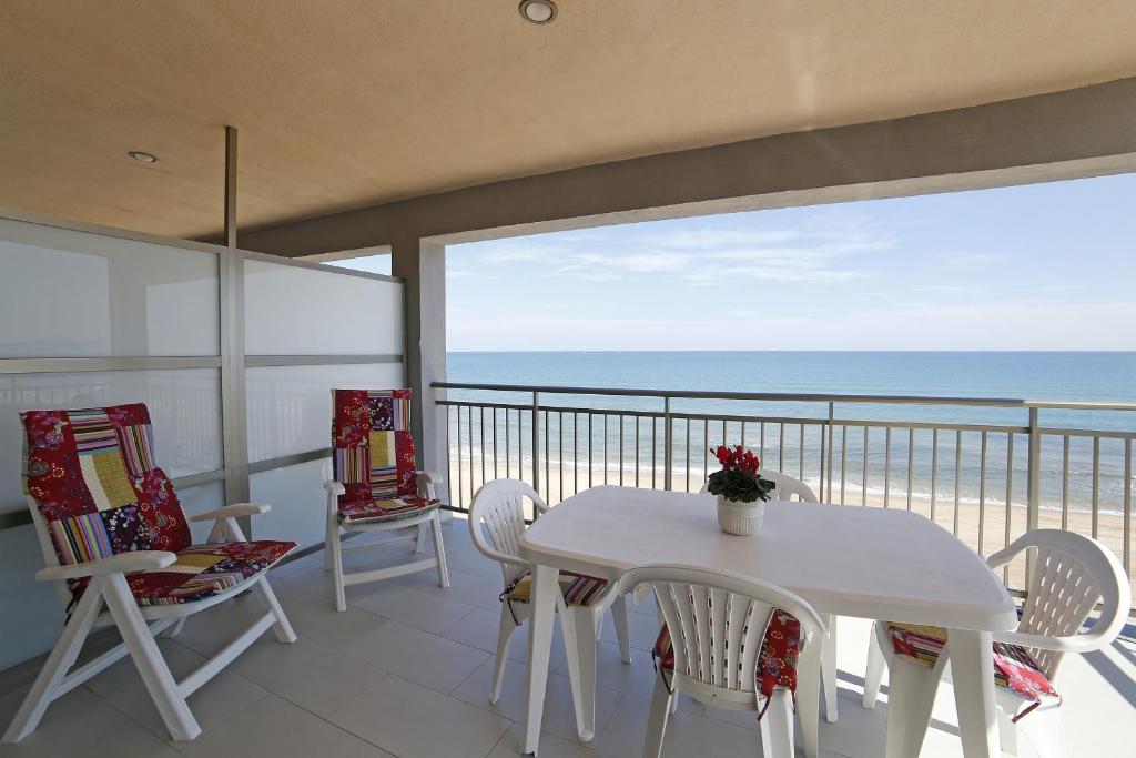 Playa de MiramarにあるApartamento Guardamar de la Saforの白いテーブルと椅子、海を望むバルコニー