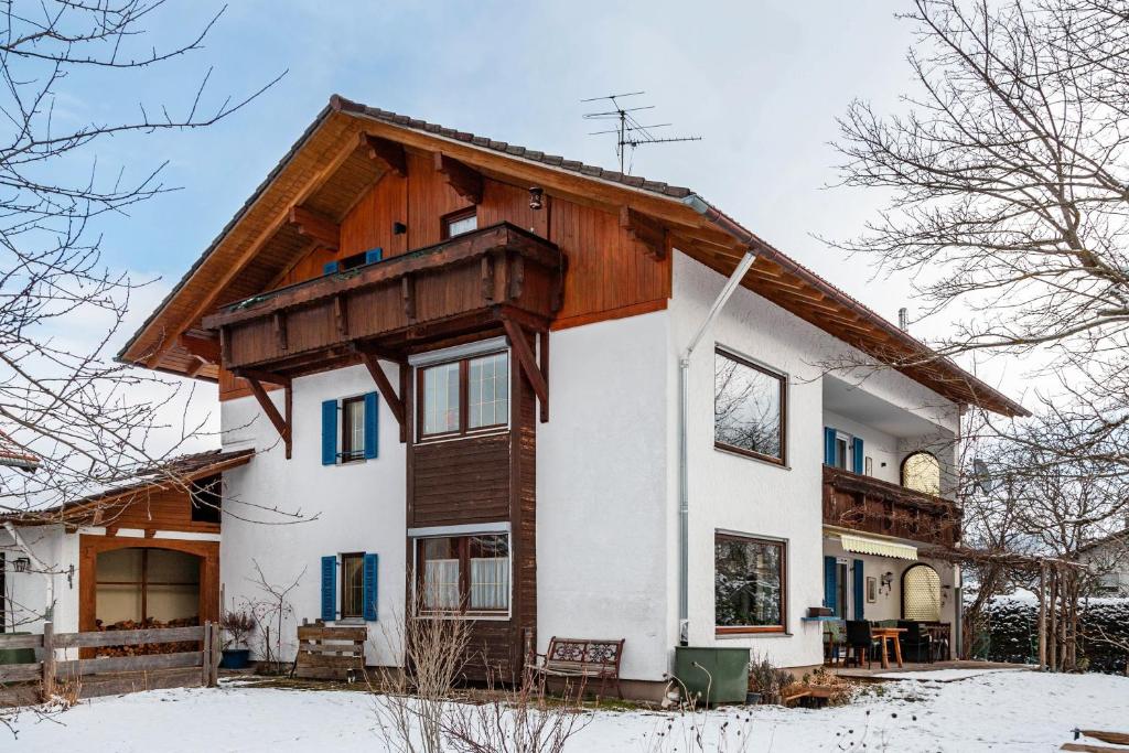 a house with a wooden roof in the snow at Haus Bergliebe in Pfronten