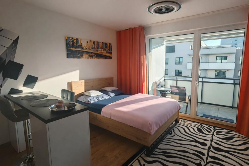 a bedroom with a bed and a desk and a window at Rezidencia Albelli in Košice