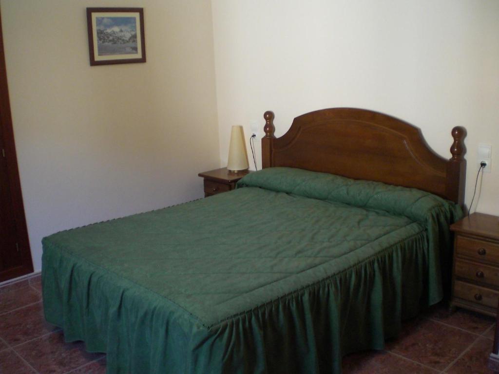 um quarto com uma cama com uma colcha verde em Apartaments Bonet em Pal