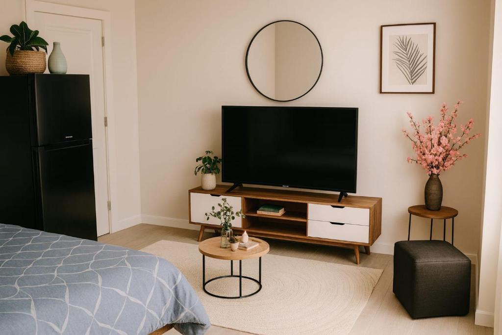 a bedroom with a flat screen tv and a mirror at CİMELi Guest House in Patong Beach