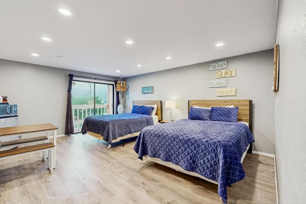 a bedroom with two beds with blue comforter at Sea Treasures Inn #210 in Rockaway Beach