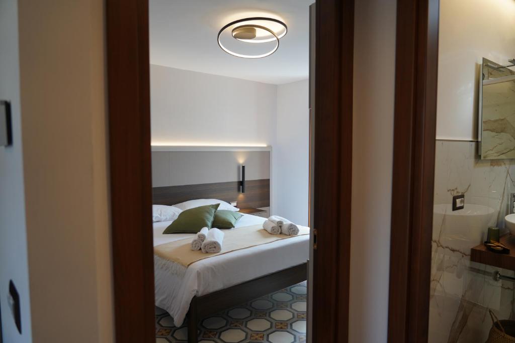 a bedroom with a bed with towels on it at Mille Mt Suites - Cercemaggiore in Cercemaggiore