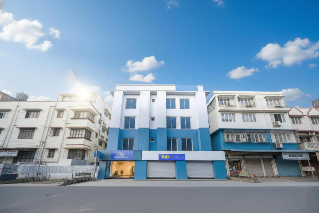 a blue and white building in front of some buildings at FabHotel MB International in Kolkata