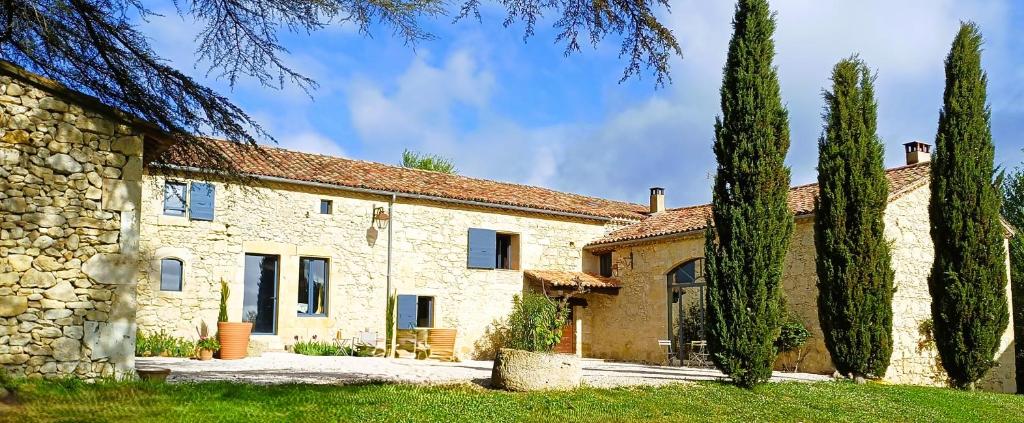 a stone house with trees in front of it at Clos Baroanni - Gîte Terra in Terraube