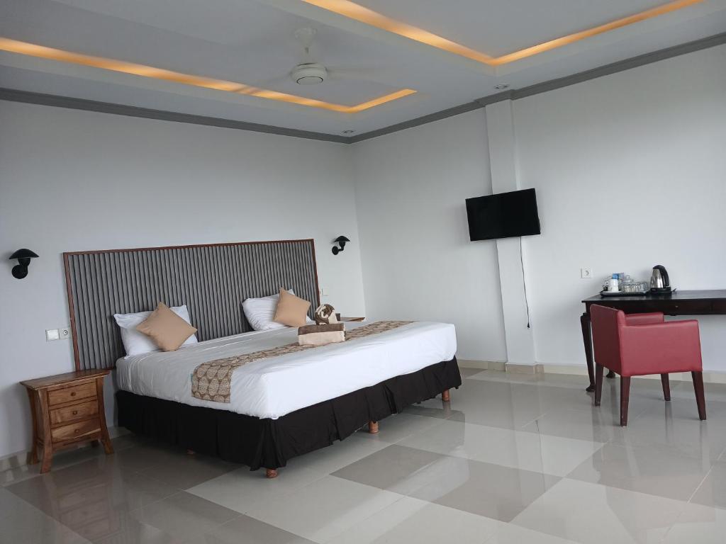 a bedroom with a large bed and a desk at Yoga bale house3 in Padangbai