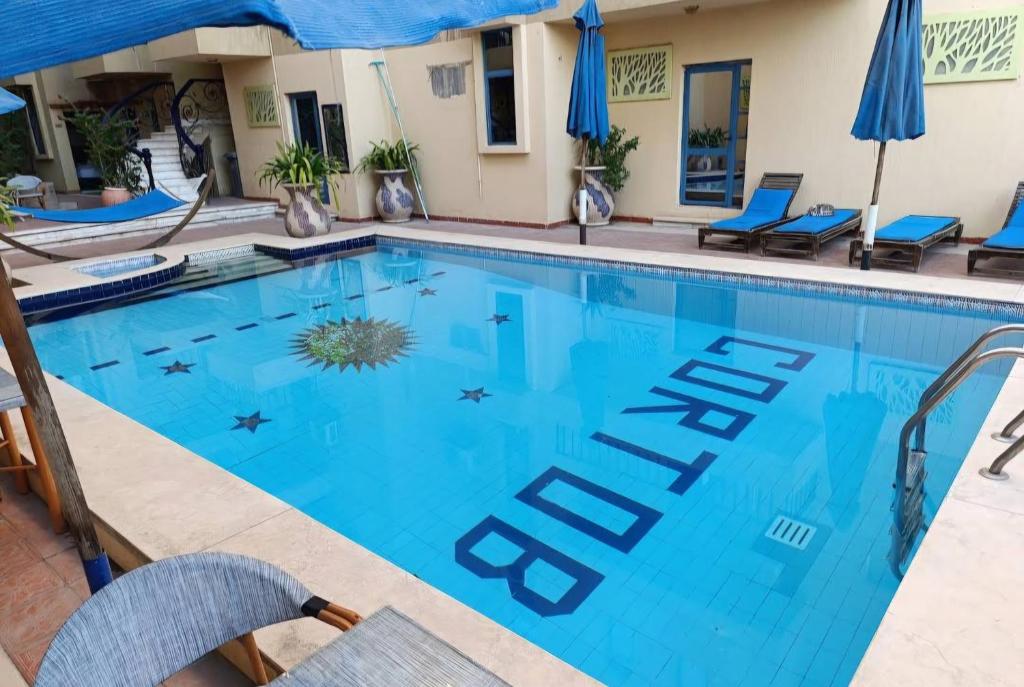a swimming pool at a hotel with chairs and umbrellas at Cordoba Suites in Hurghada
