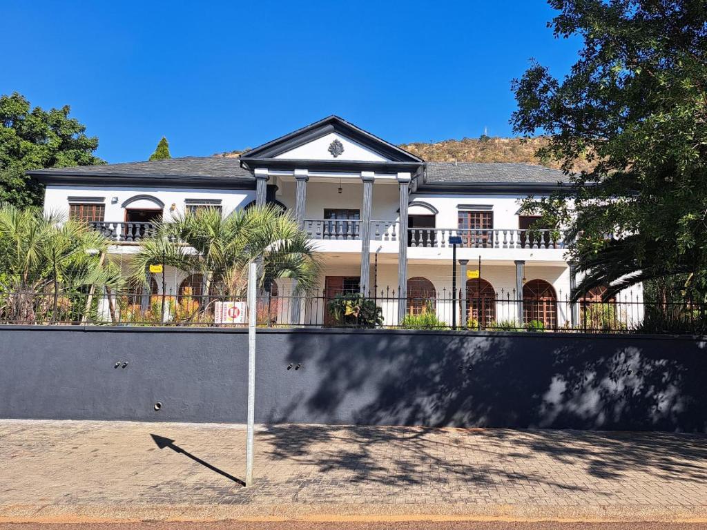 a large white house with a sign in front of it at Namloom Guesthouse in Pretoria