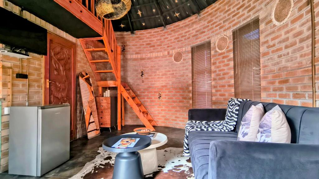 a living room with a blue couch and a brick wall at Bavarian Maun Apartments in Maun