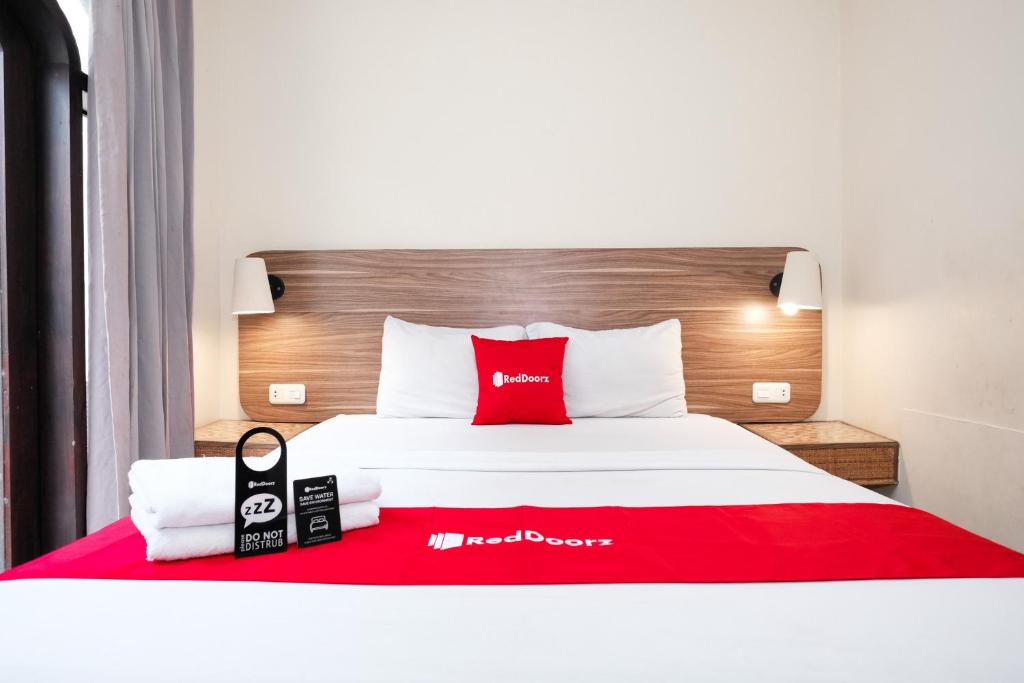 a hotel room with a red and white bed at RedDoorz @ Wiyung 2 in Kedurus