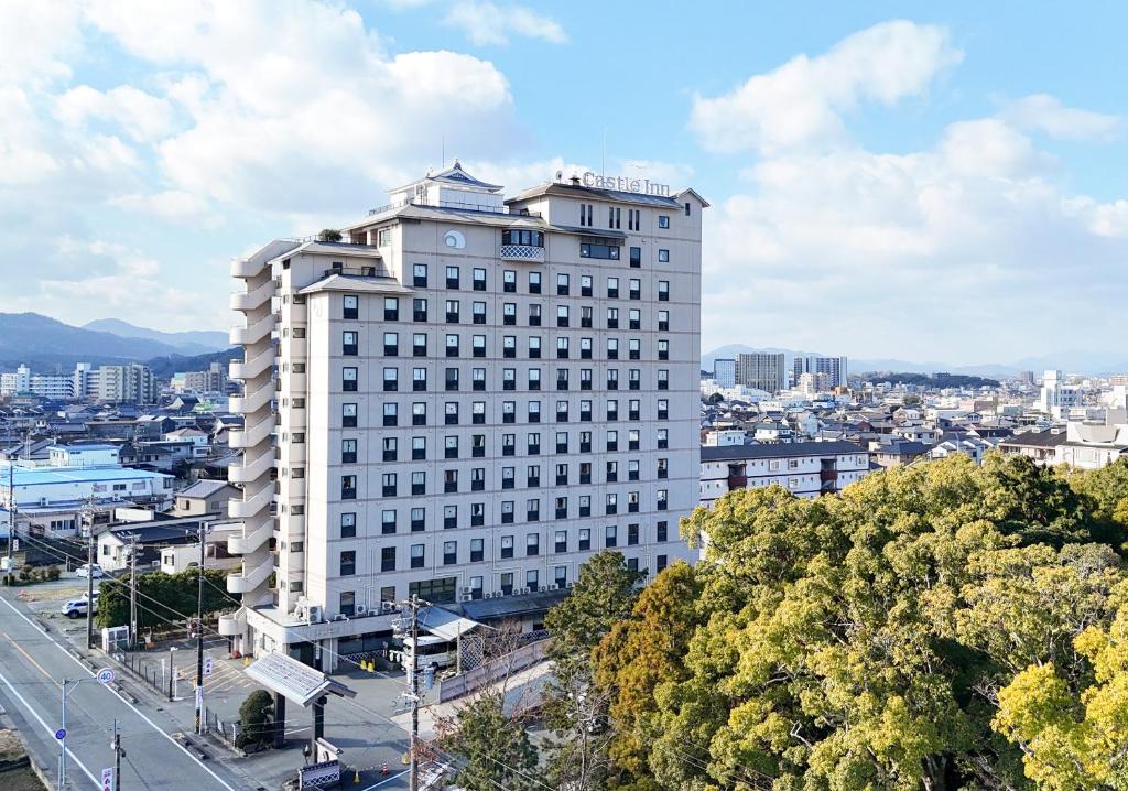a tall white building with a city in the background at Hotel Castle Inn Ise in Ise