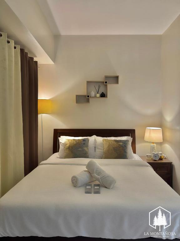 a bedroom with a bed with two pillows on it at Solace - 1BR Brenthill Condo with Balcony Near Session and SM in Baguio