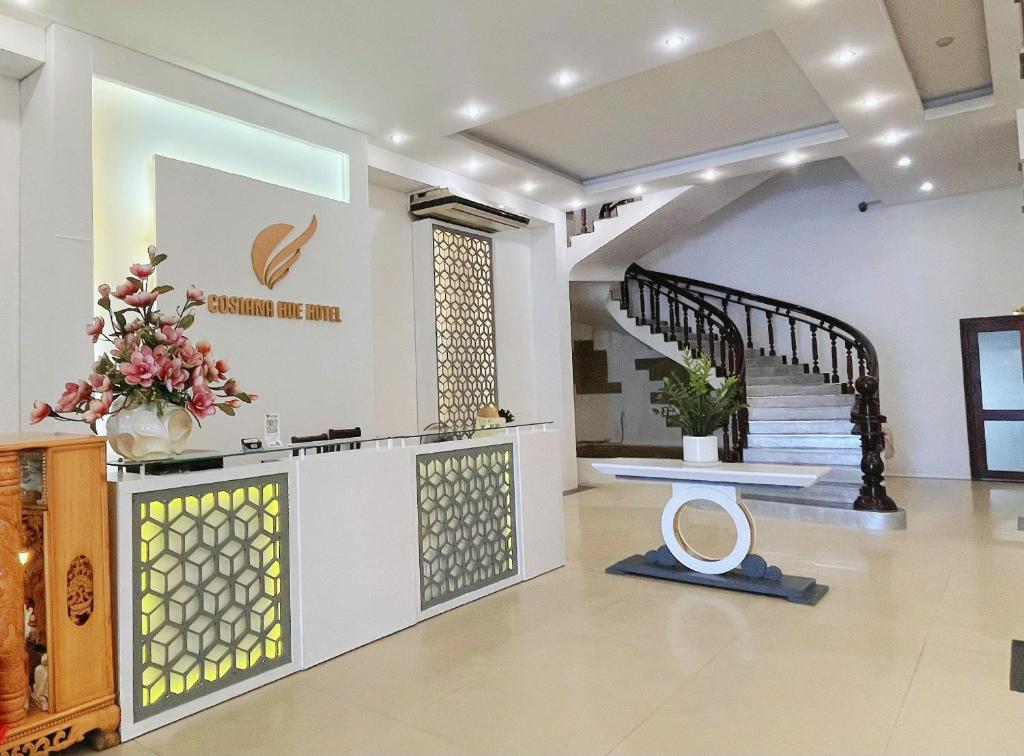 a living room with a staircase and a stair case at Cosiana Hue Hotel in Hue