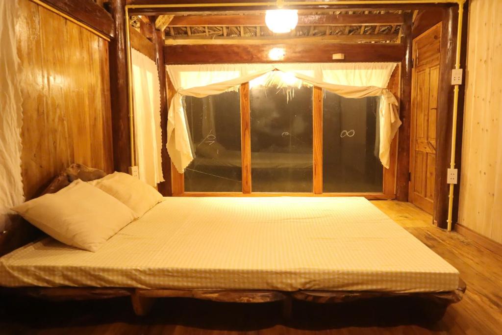 a bed in the middle of a room at little Island in Na Lúng
