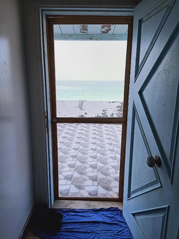 an open door with a view of the beach at On the Beach Villa Apartment in Alexandria