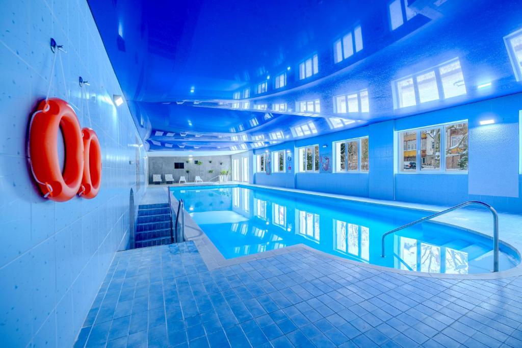 a swimming pool in a building with blue lighting at Dobrzyński Resort Topaz in Świeradów-Zdrój